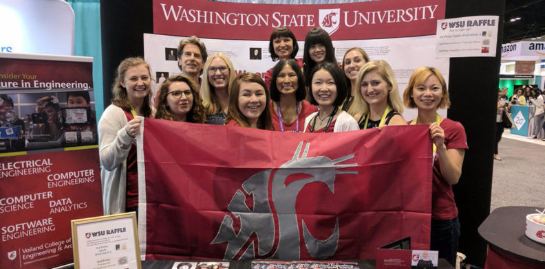 Women engineers posing with the WSU cougar flag at the Grace Hopper Convention.