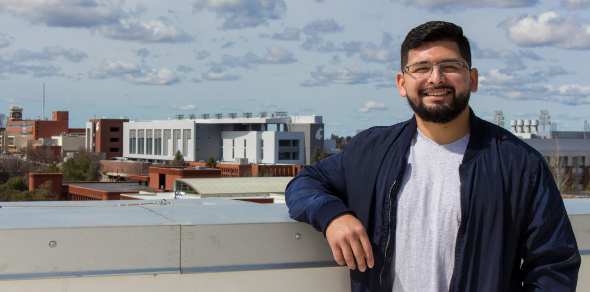 Yoni Rodriguez leans against the railing on a building roof.