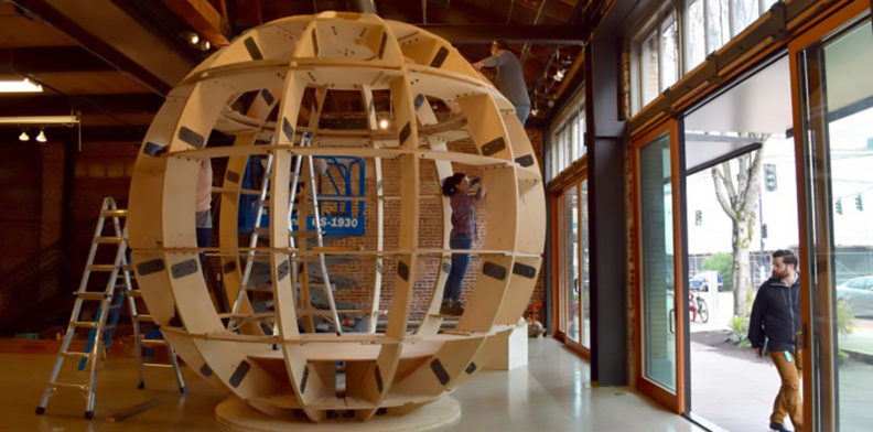 Miyasaka working on a giant wooden spherical sculpture.