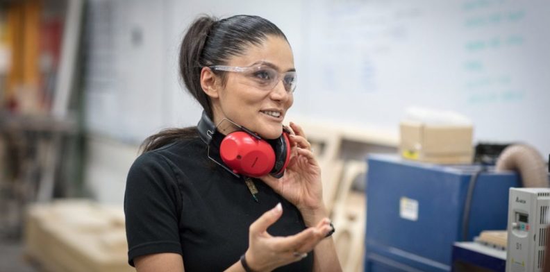 Mona Ghandi wearing safety glasses and putting on ear protection.