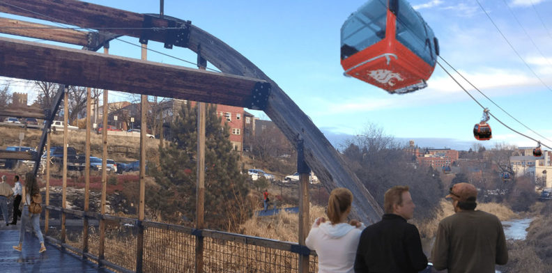 A pedestrian bridge in Pullman, WA with gondolas overhead.