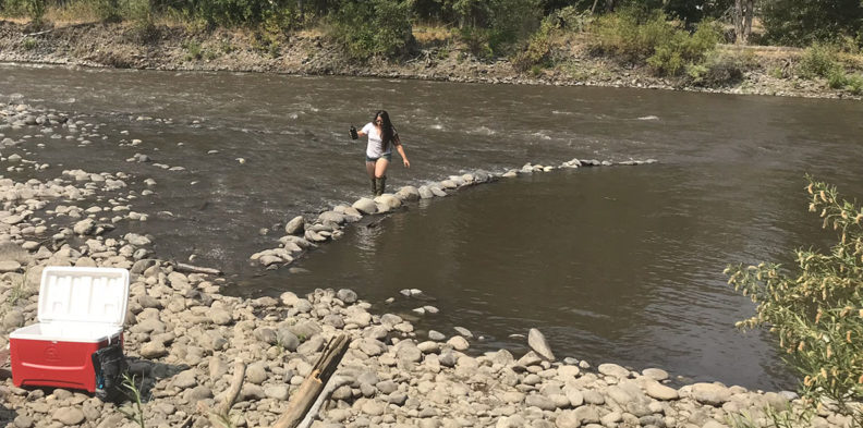 Asa Reyes-Chaves fords the river toward her gear on the bank.