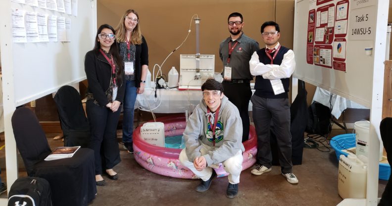 Five students pose next to their competition submission.