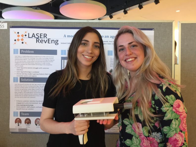 Kiera Rust standing next to Samantha Grindrod who is holding a prototype of their laser tag blaster.