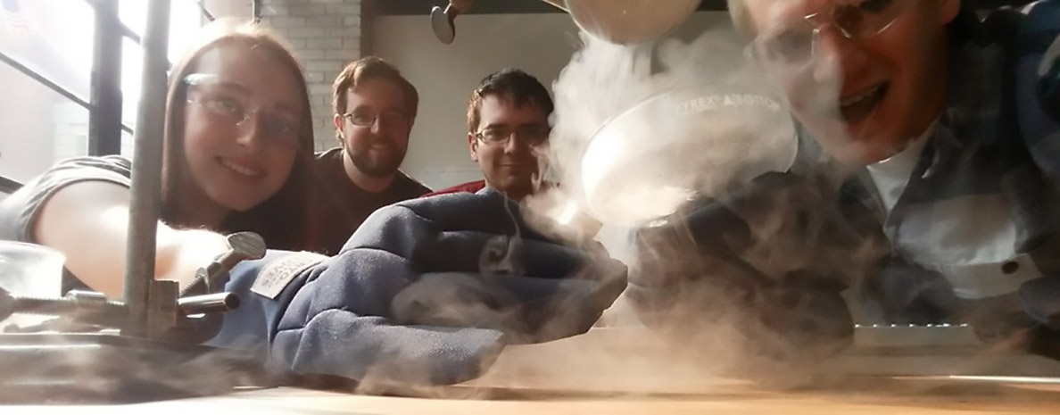 Jordan Raymond and three colleagues wear safety glasses and gloves while magnetizing liquid air.