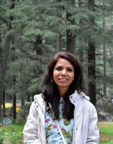 Neeru Chaudhary in front of trees.