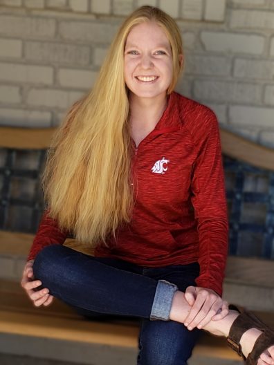Jessica Erickson seated on a bench and wearing WSU Cougar spirit gear.