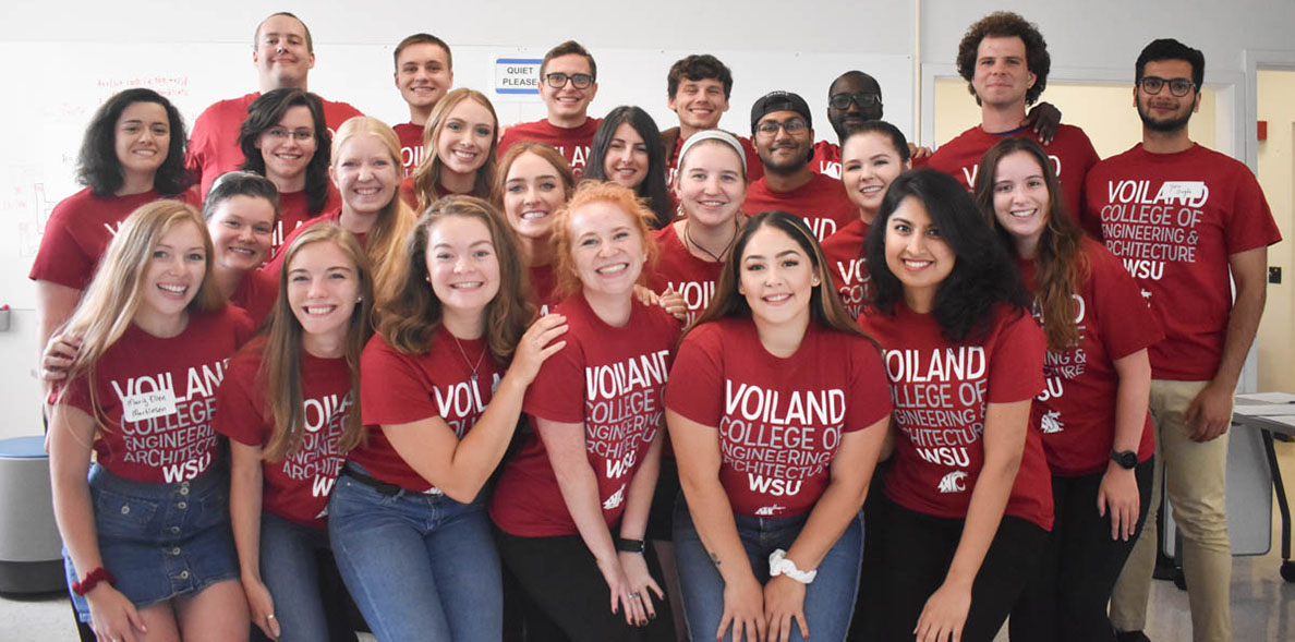 Voiland College ambassadors wearing crimson t-shirts pose in four rows for a group picture.