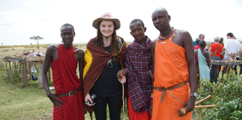 Thayer stands with three Maasai tribe members.