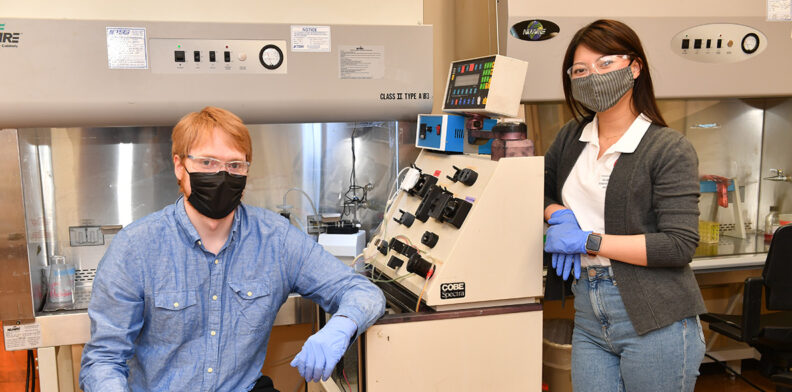 Graduate students Kitana Kaiphanliam and Brenden Fraser-Hevlin pose for a picture in the lab.