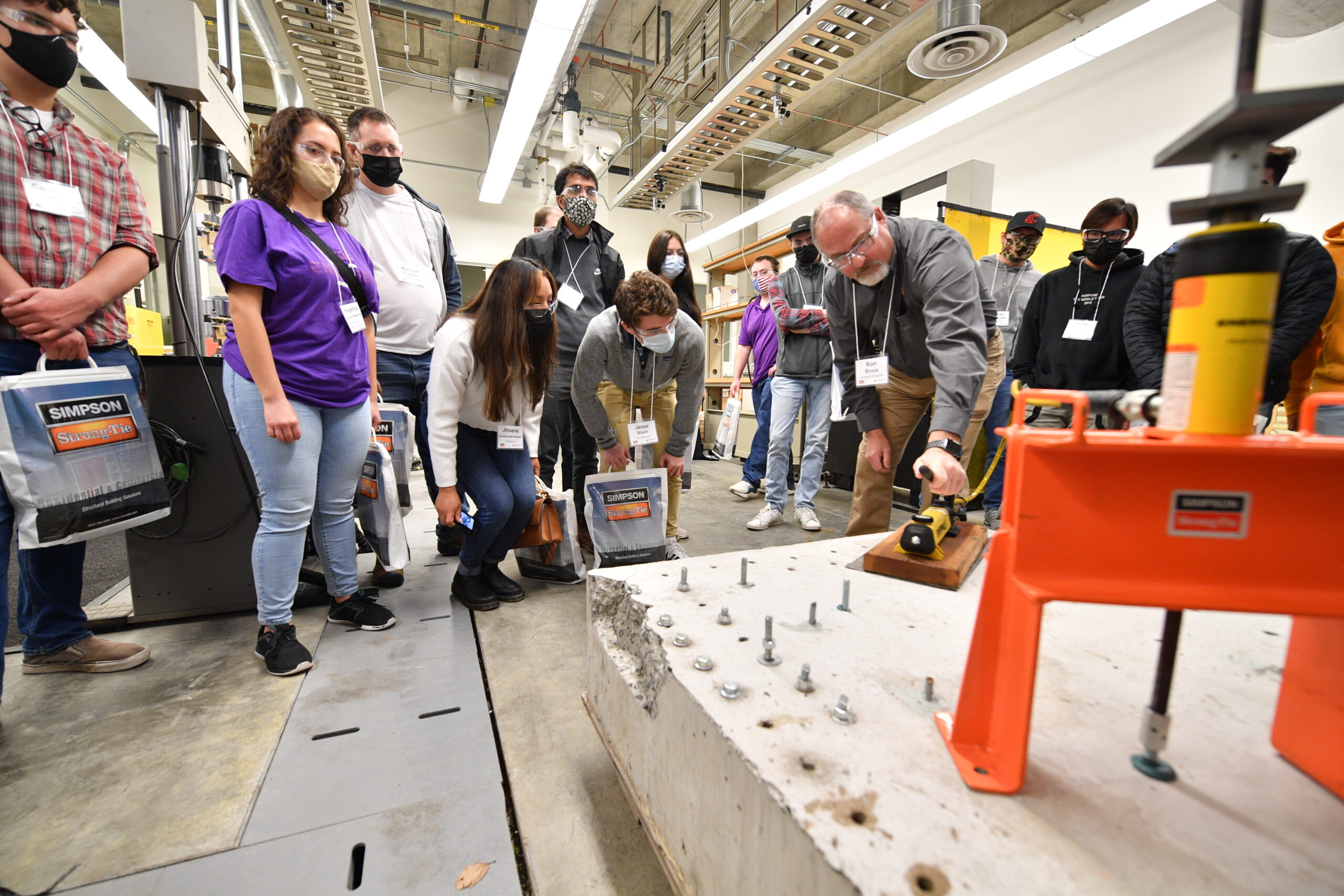 Man demonstrating use of concrete fasteners for a group of students.
