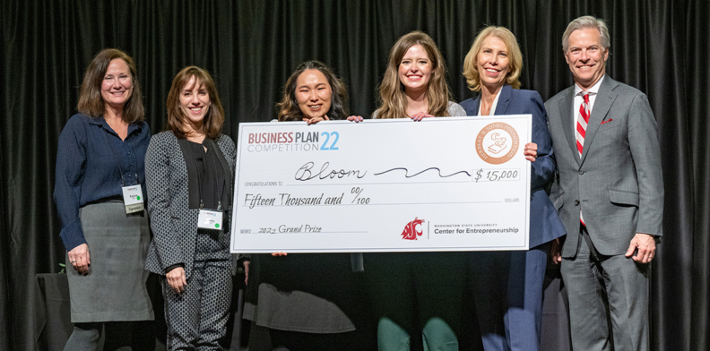 People holding a giant check for $15,000.