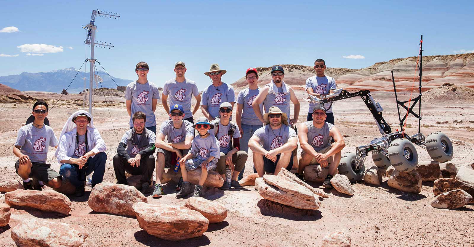 WSU Mars rover team poses in the desert with their rover.