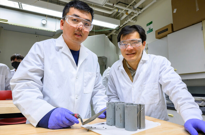 Graduate student Zhipeng Li and Professor Xianming Shi next to a carbon-negative concrete sample.