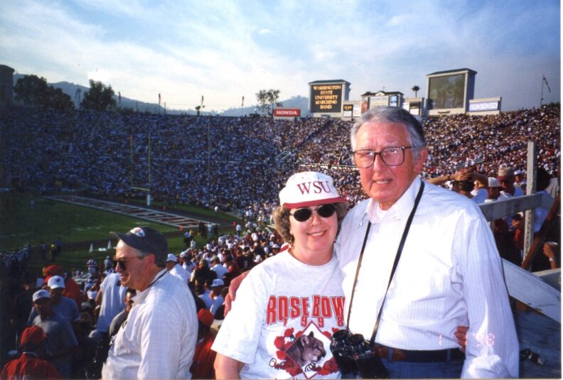 Two people pose in the stands during a WSU football game.