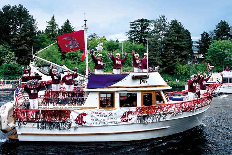 WSU alumni wave from a yacht decorated with crimson and silver streamers.