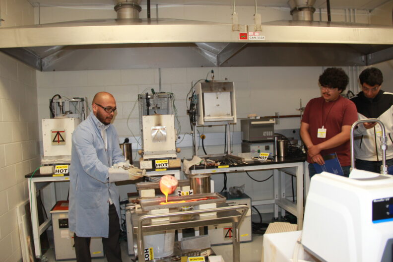Scientist pours molten glass onto a tray.