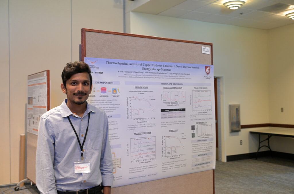 Kavin Chakravarthy Thangaraj standing next to a presentation poster.