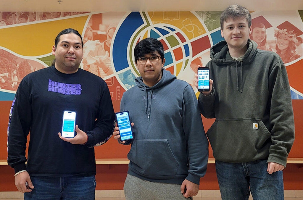 Students showing their music app running on different mobile phones.