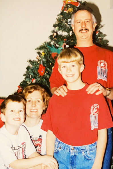 Family posing in front of a Christmas tree.