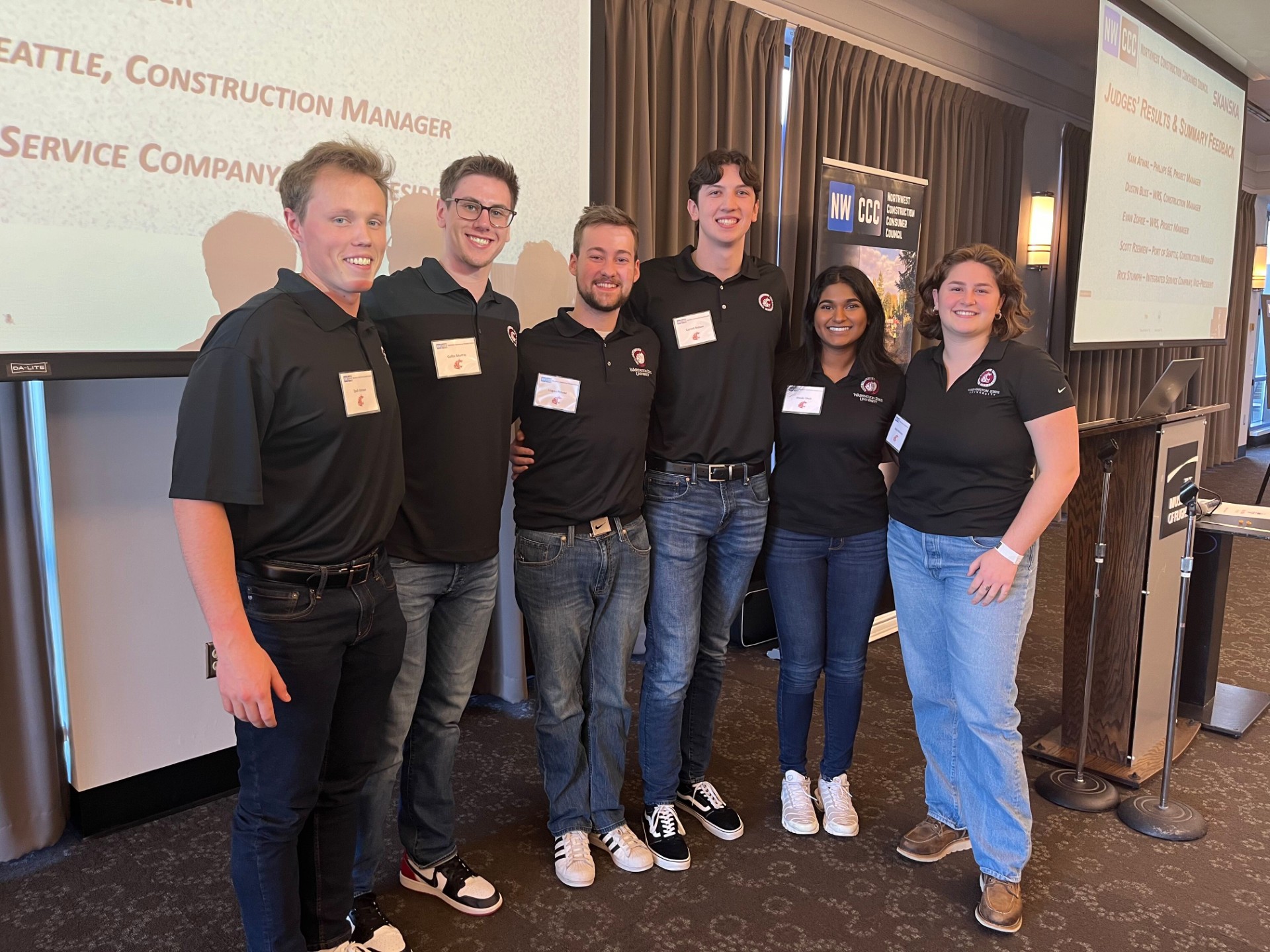 Six people posing in a conference room.
