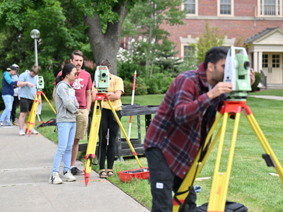 Students practicing with surveying equipment.