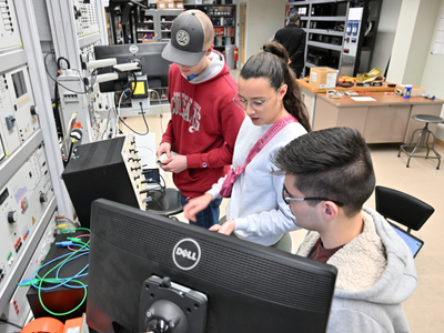 Three students working with electrical equipment.
