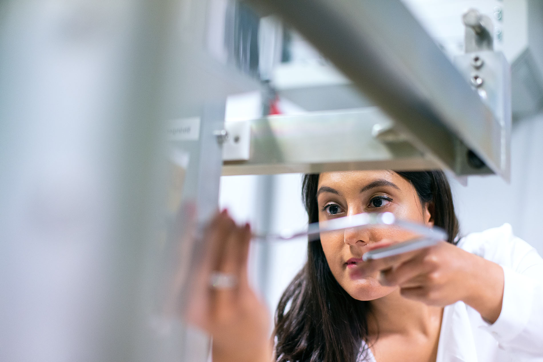 Person in a lab working on a machine.