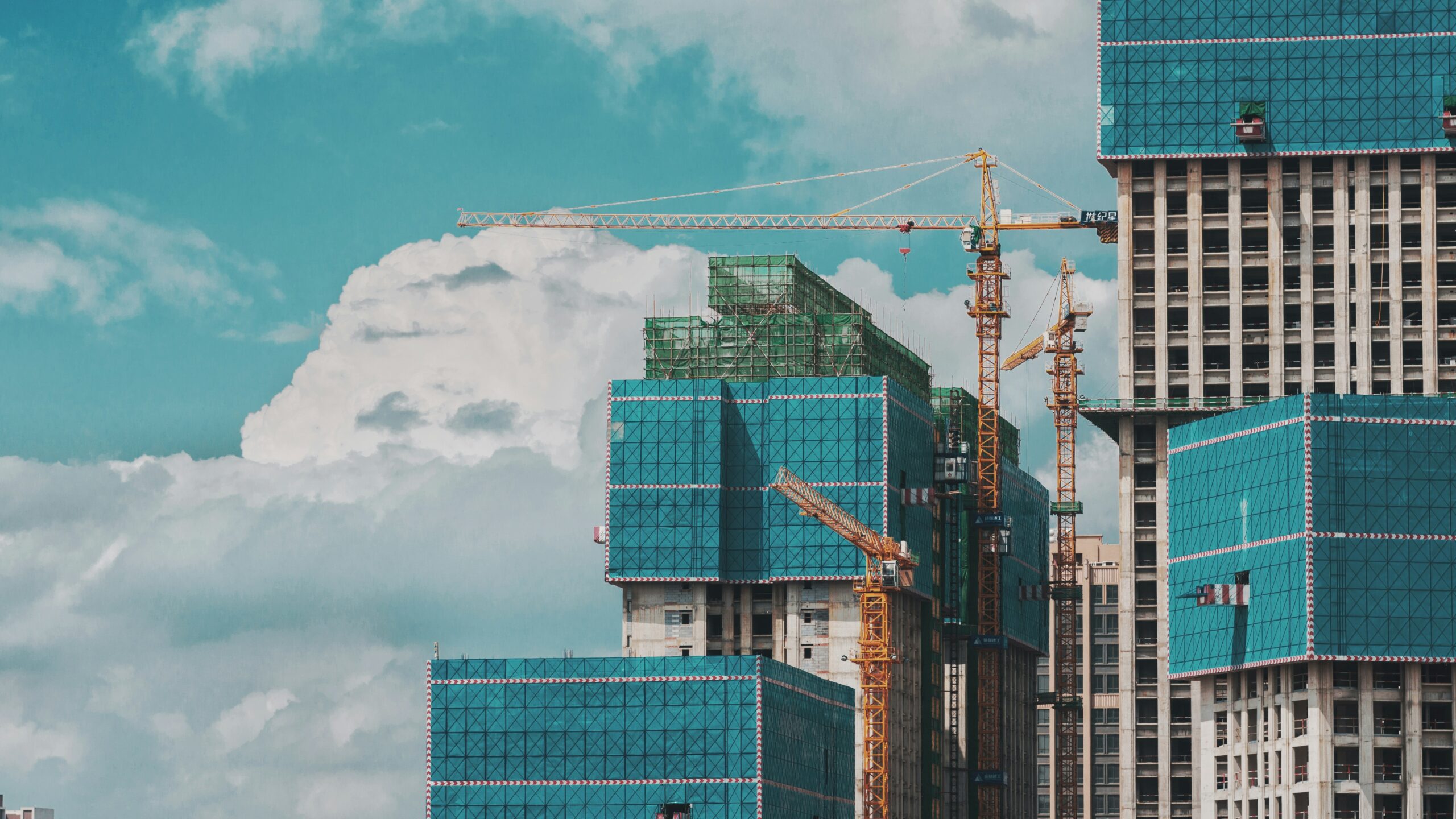 Construction cranes in use to build a tall skyscraper.
