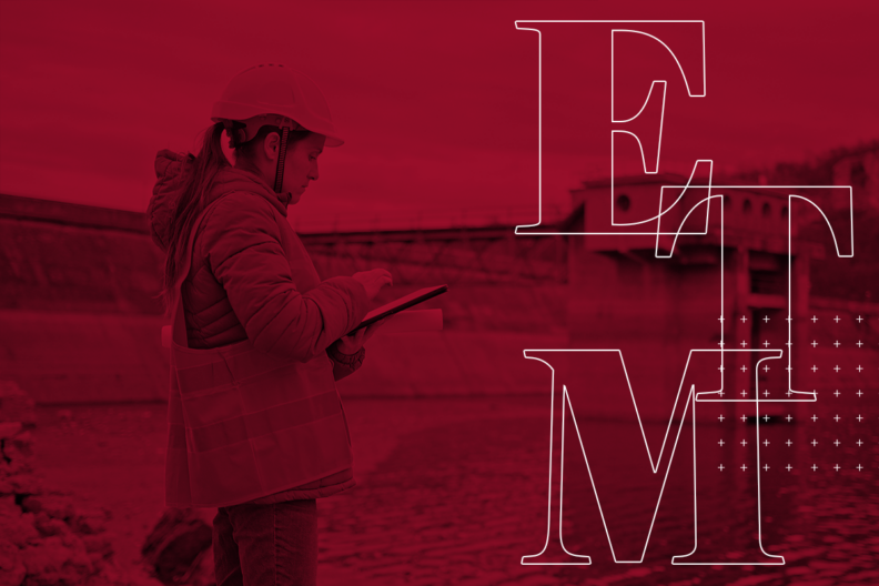 A red-tinted image of a construction site near a body of water, showing a person wearing a hard hat and safety vest using a tablet. t. Concrete dam structures and industrial infrastructure are visible in the background. Large outlined letters “E,” “T,” and “M” overlay the right side of the image alongside a pattern of small plus signs.