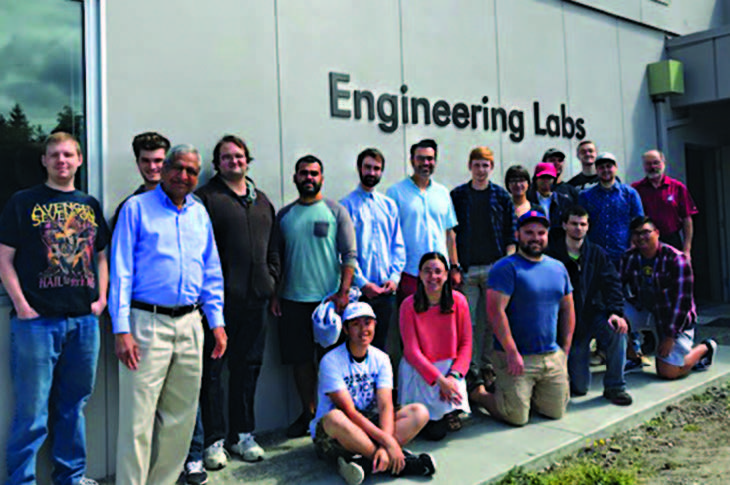 Group of people posing under a sign that reads Engineering Labs.