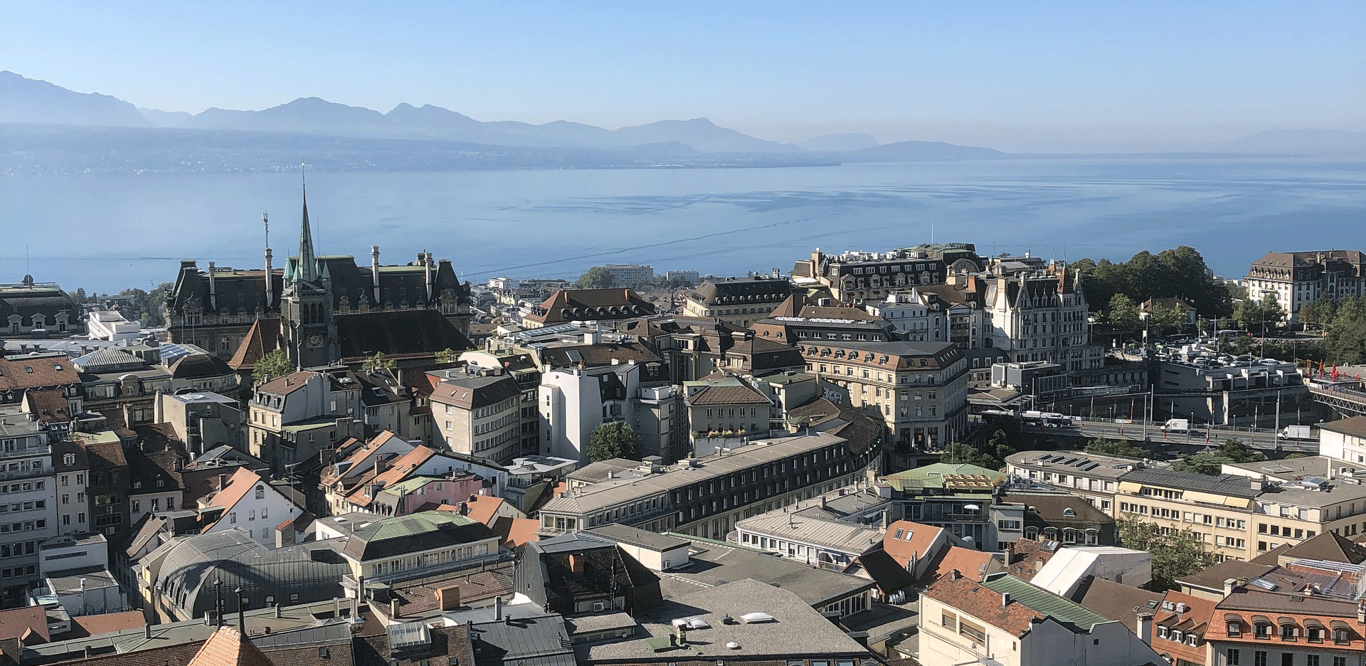 Aerial view of buildings, ocean, and mountains.