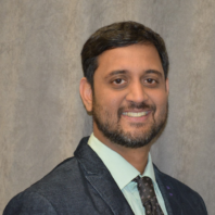 Smiling man wearing a suit and tie.