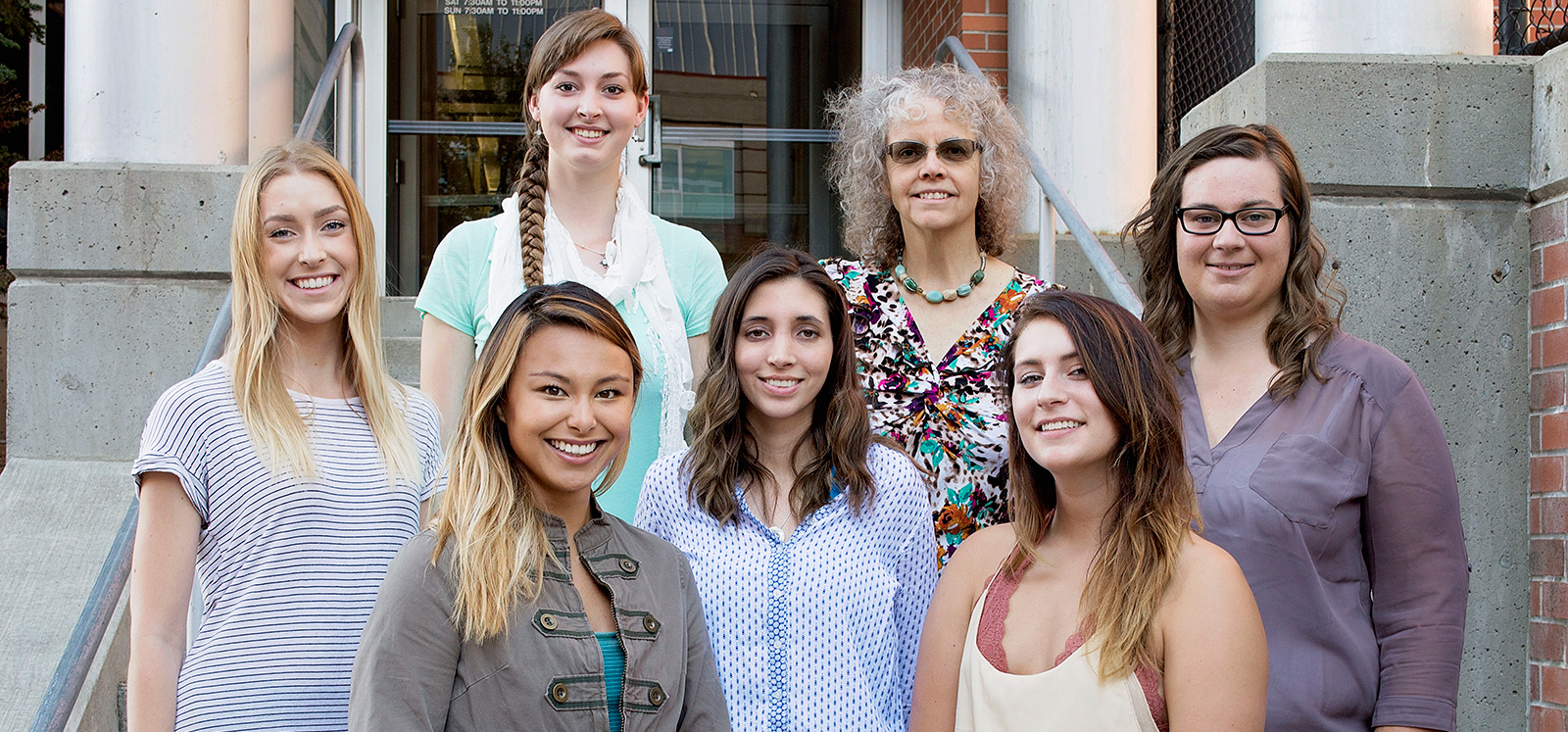 Seven women standing on the steps of a building.