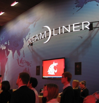 People walking past a wall displaying the Dreamliner logo and the WSU cougar logo.
