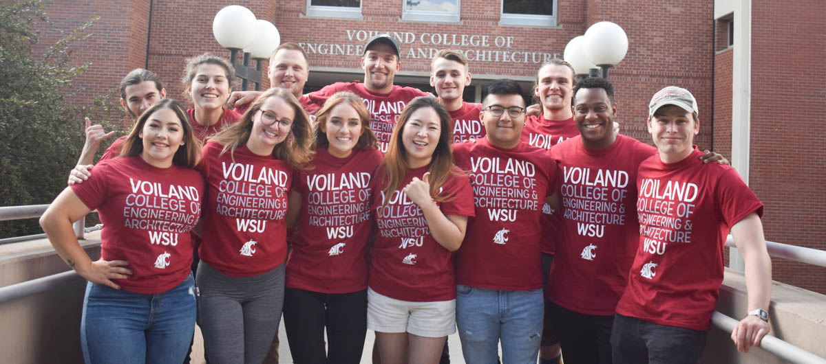 Voiland College tutors wearing crimson t-shirts pose in two rows for a group picture.