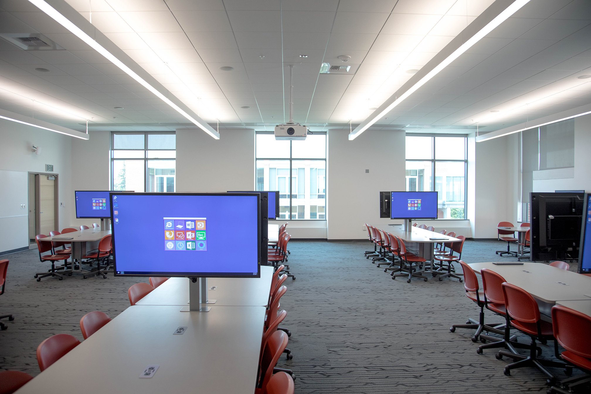 Empty classroom with monitors on each table.