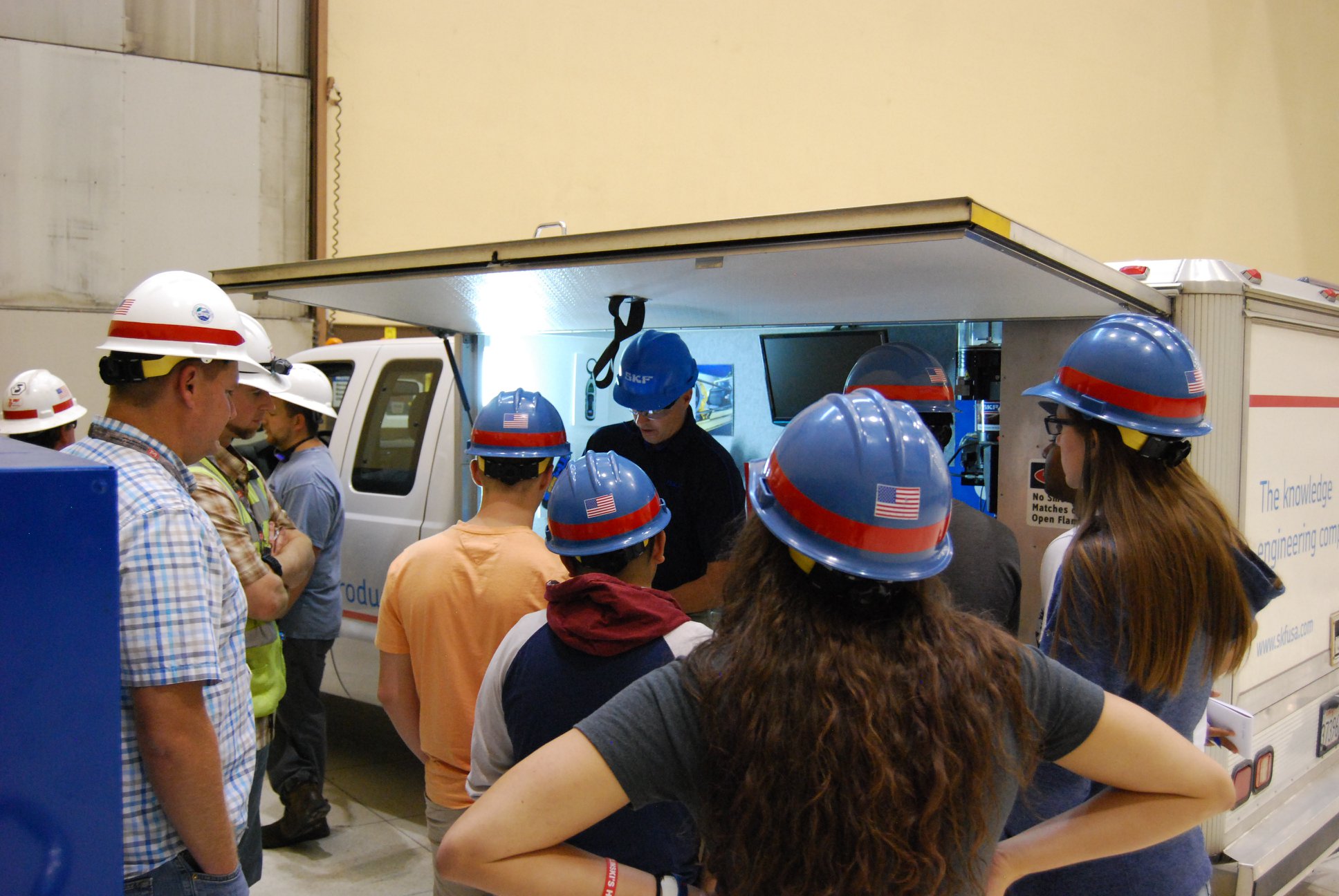 Students wearing hard hats listening to an employer presentation.