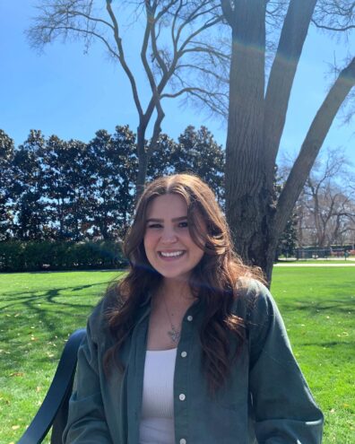 Maya Salsbury standing in front of a tree.