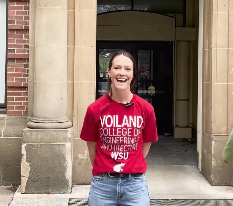 Student wearing a Voiland College t-shirt in front of a brick and cement building.