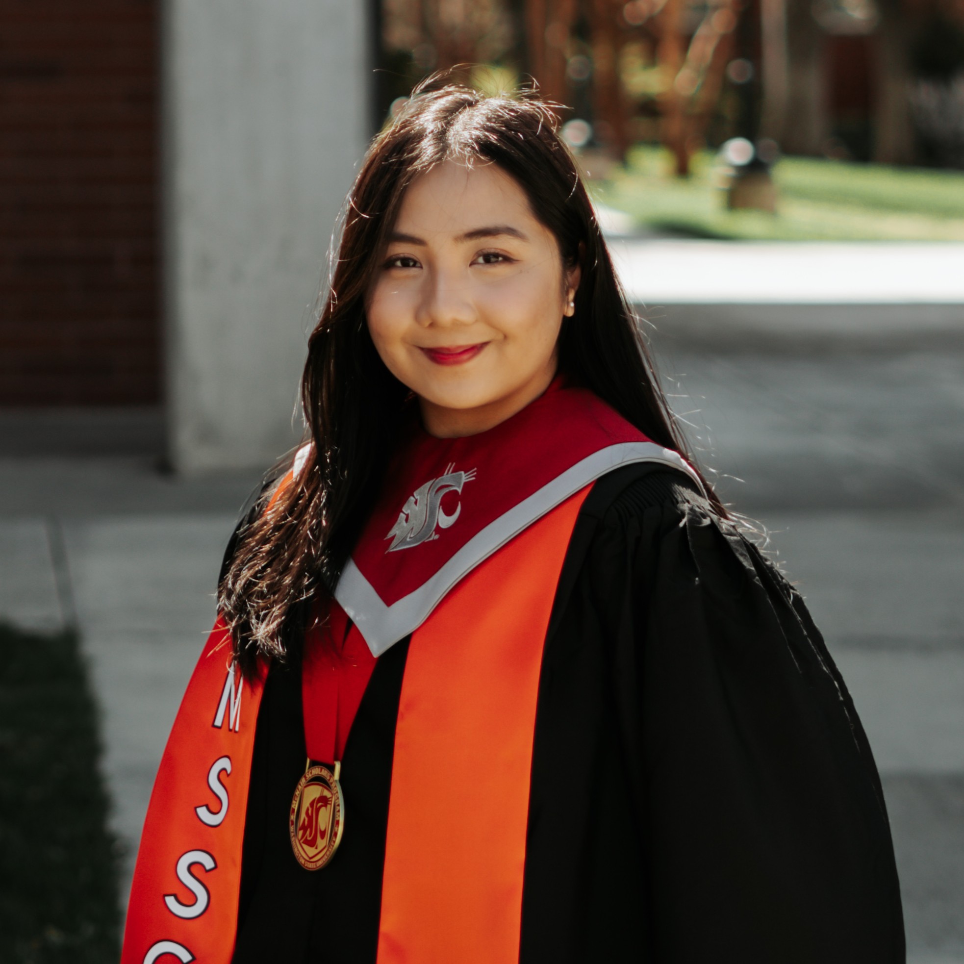 Akira Park. A girl wearing a graduate regalia, smiling.