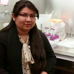 Sujala Sultana sitting next to lab equipment.