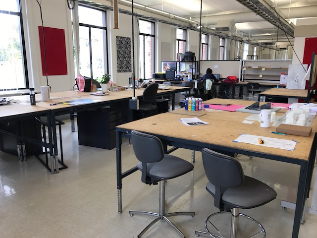 Pictured is the design studio in Carpenter Hall containing individual work spaces, such as high-adjustable tables, chairs, and pin-up boards, along with extension cords on each space.