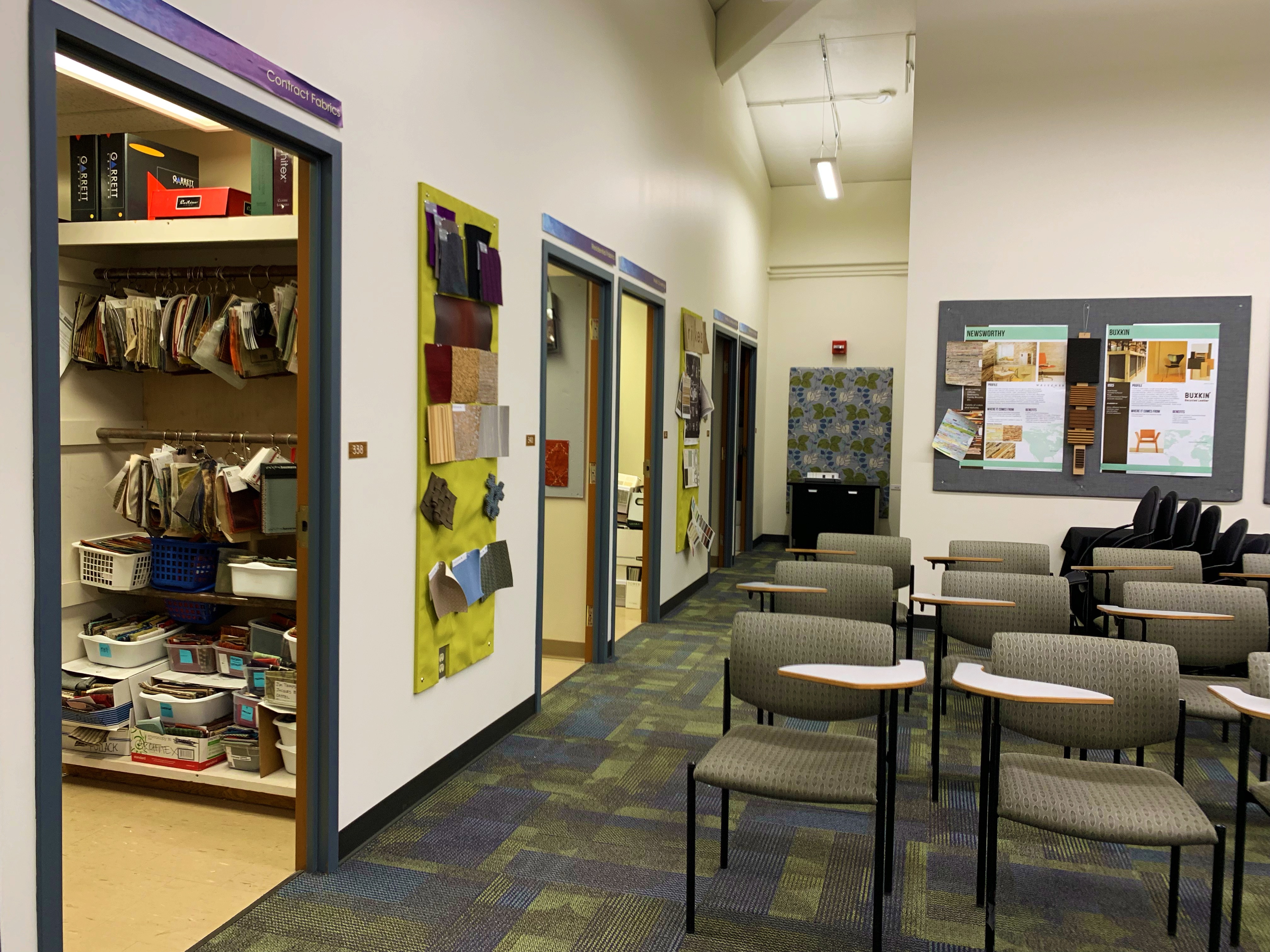The photo shows a lecture room with tablet armchairs at the center and several material storage rooms surrounding the room.
