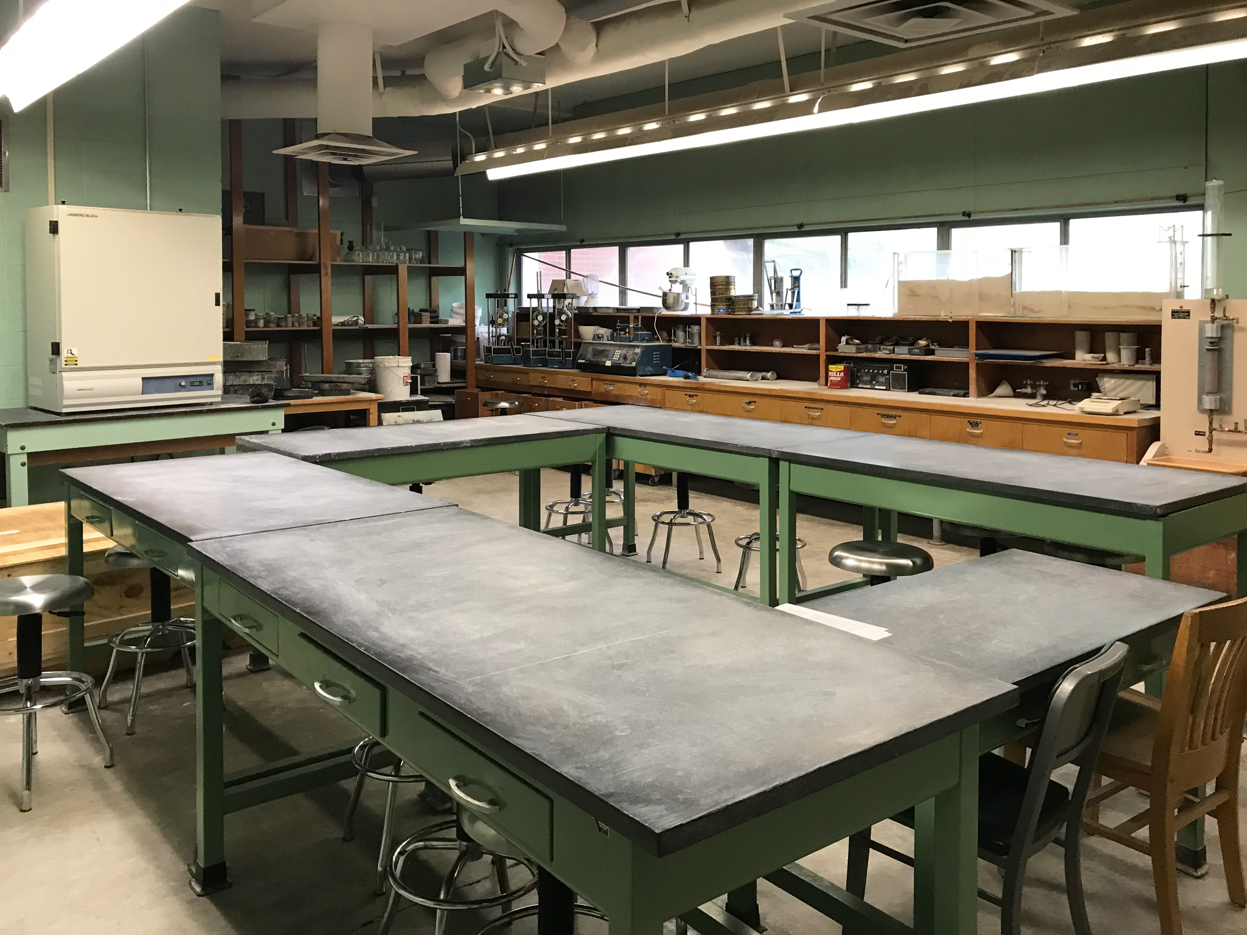 The picture shows tables and chairs in the middle of the room as well as soils equipment in the surrounding area to use for research.