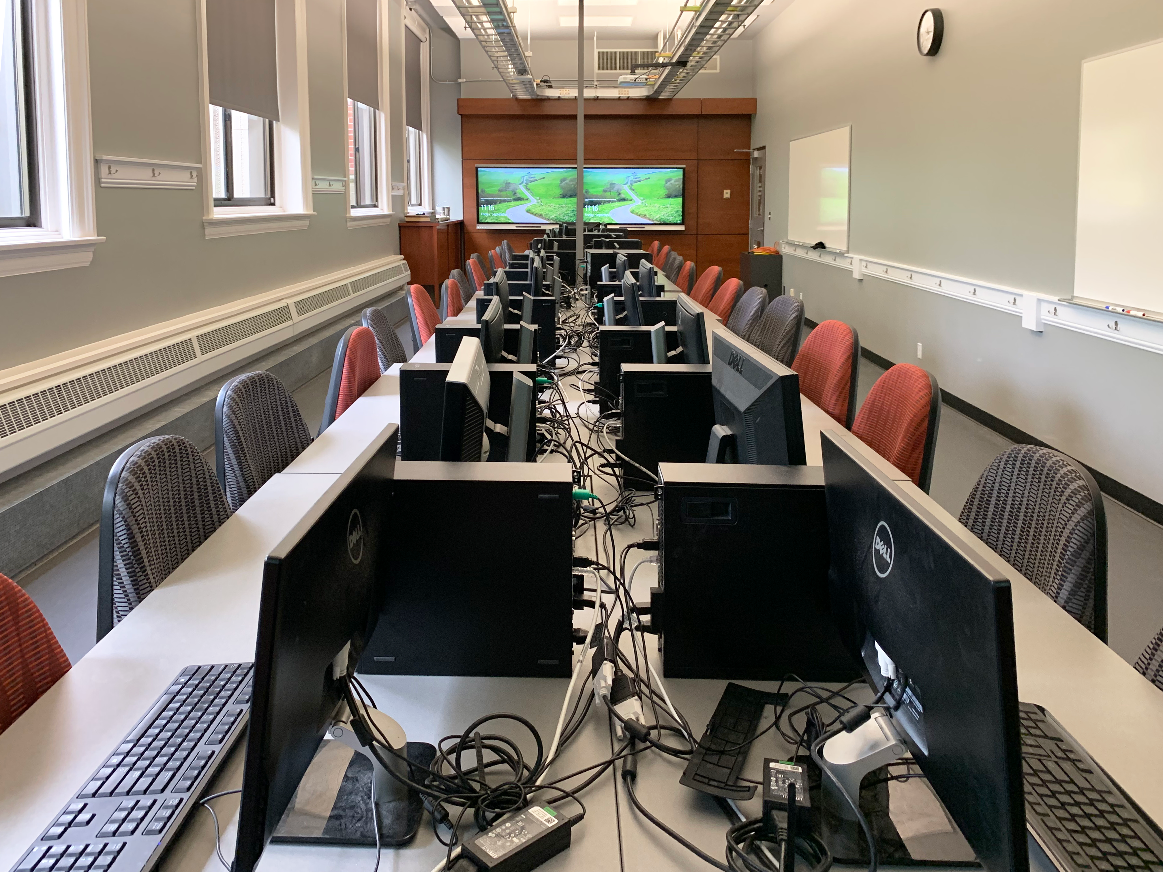 The room contains several computer stations as well as presentation monitors on each end.