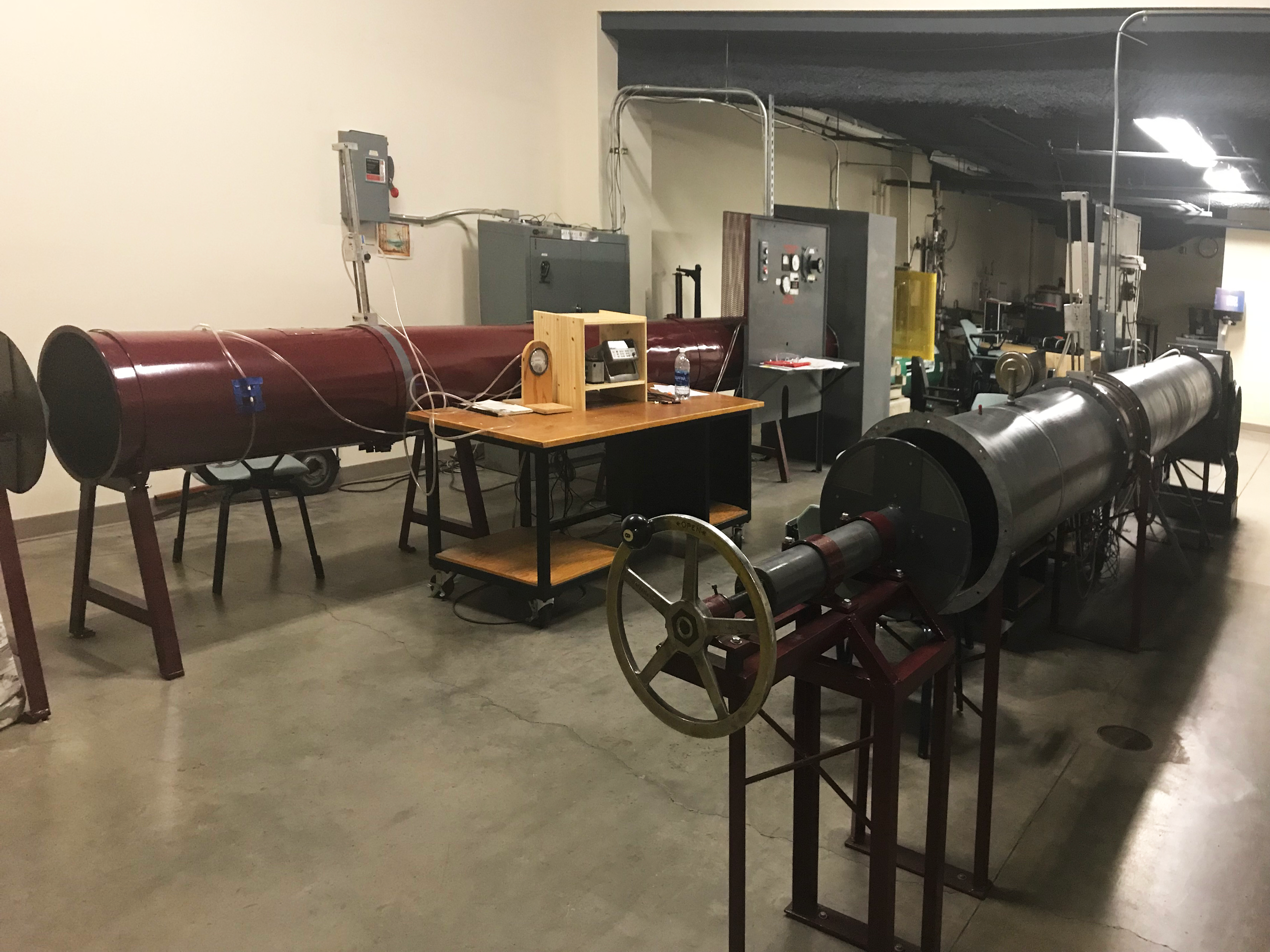 The image shows a centrifugal fan, an axial fan wind tunnel, and several other mechanical equipment utilized in the Experimental Design Lab.