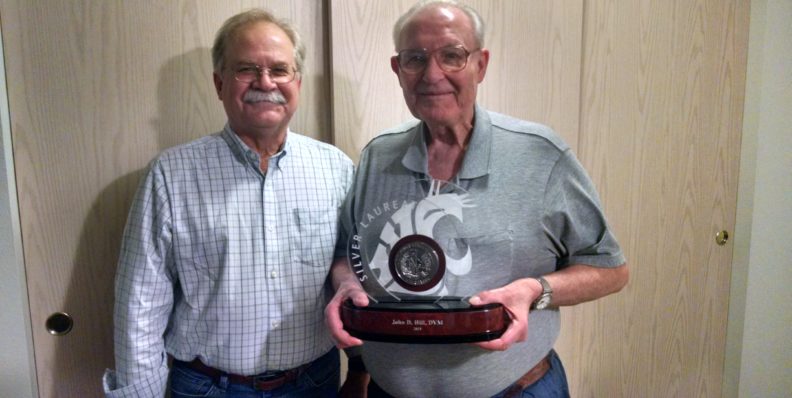 John Hill holding his silver laureate statue with Bryan Slinker