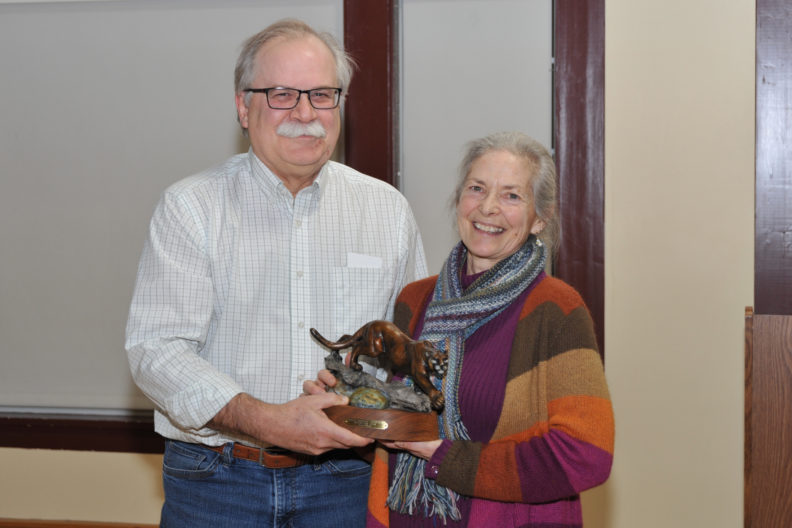 Kathleen Potter holding a cougar statue with Bryan Slinker