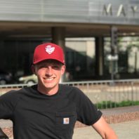 Pierce sitting on the steps next to a statue outside the clinic